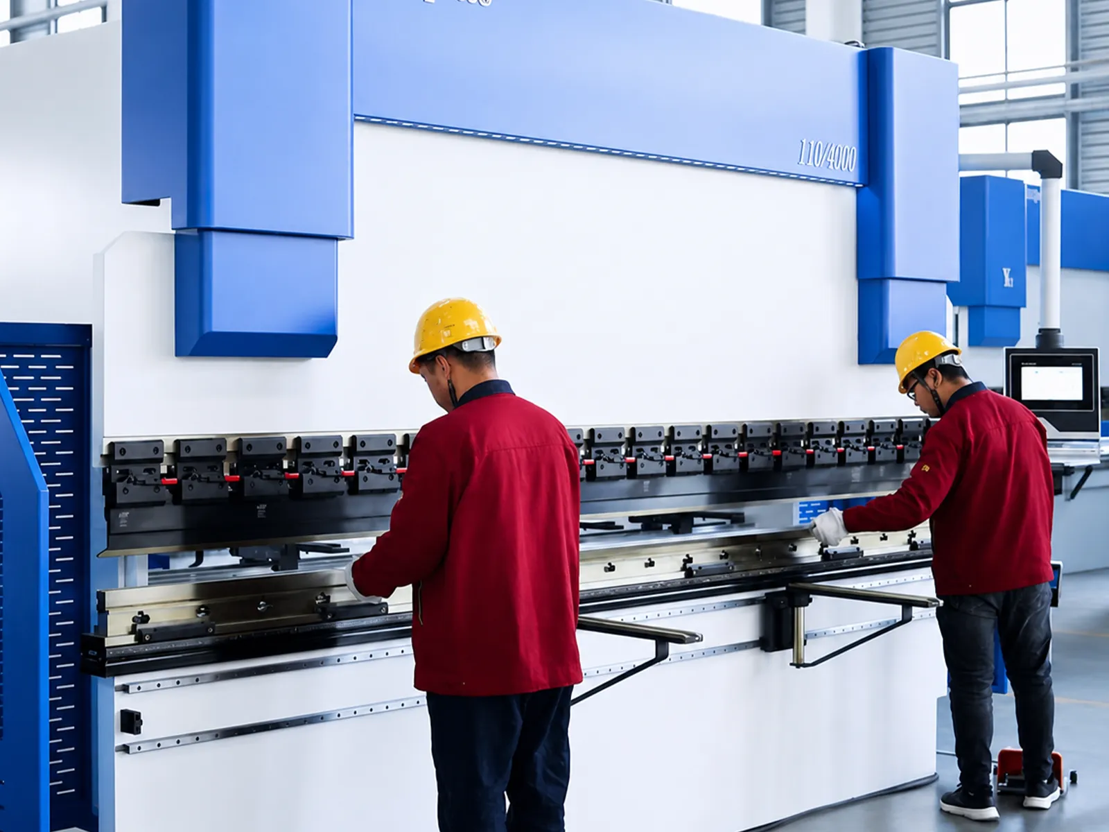 Técnicos operando una plegadora durante una prueba de máquina