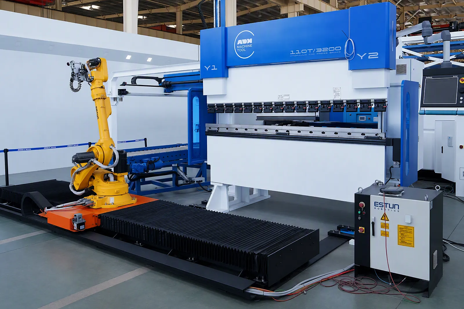 Plegadora y robot industrial dispuestos como una célula de plegado automatizada